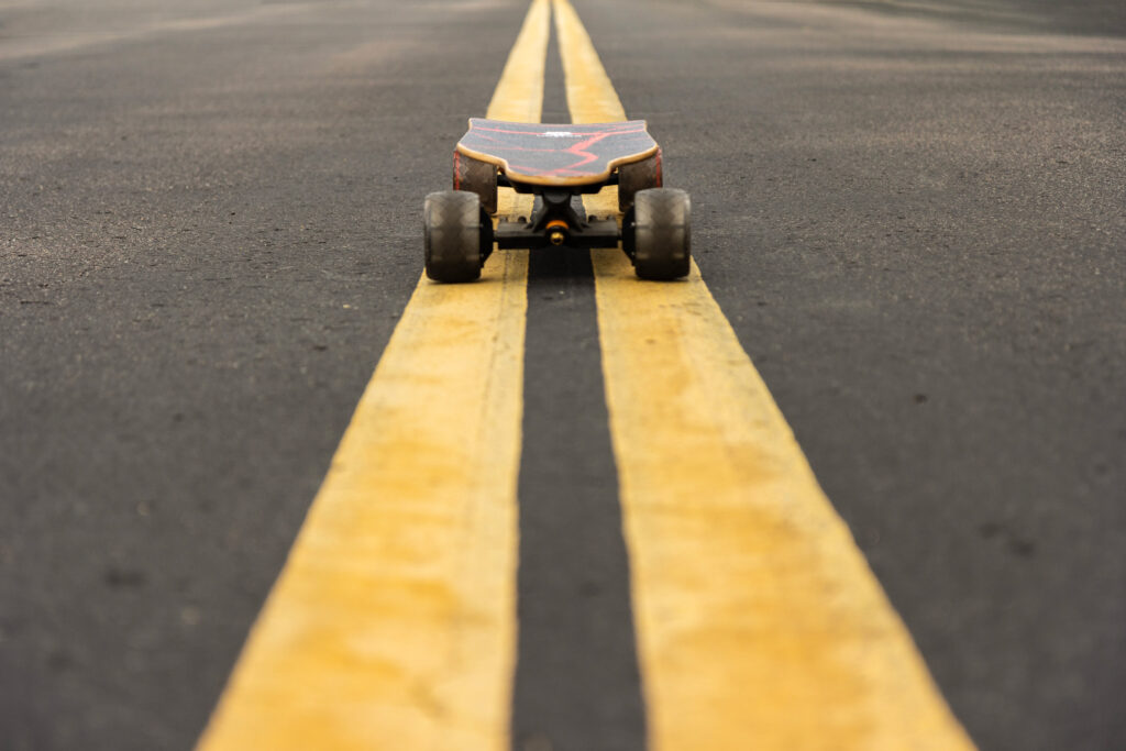 electric skateboard on yellow road stripe